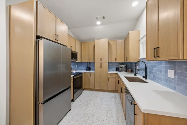 a kitchen with kitchen island granite countertop cabinets and stainless steel appliances