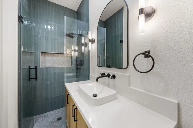 a bathroom with a sink vanity toilet and shower