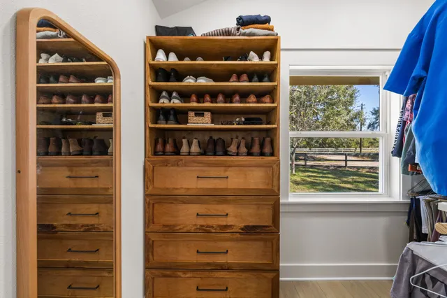 a view of walk in closet with clothes and shoes