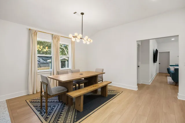 a room with chandelier fan and wooden floor
