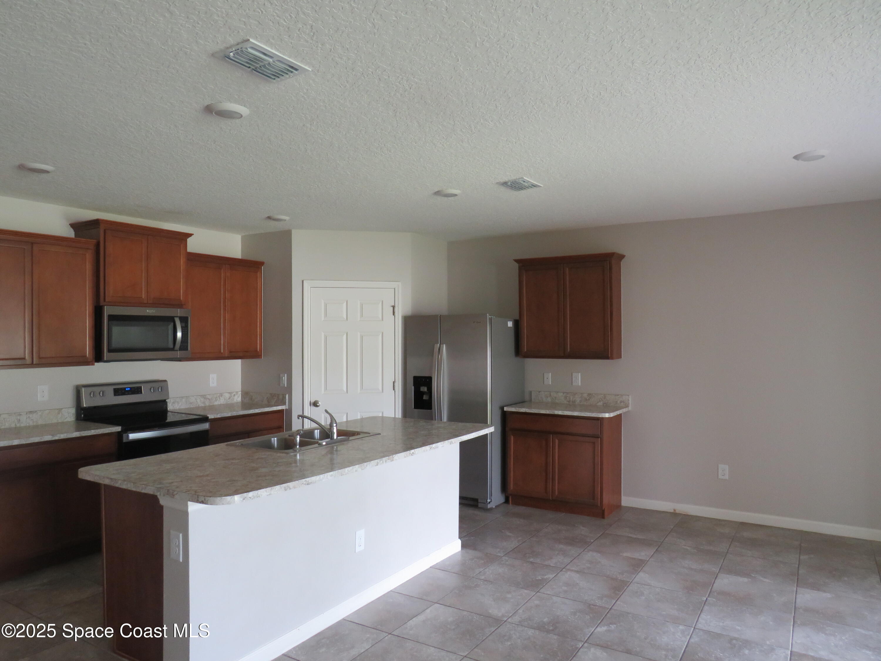 3548 Loggerhead Lane Mims, FL 32754 - Photo 4 of 25 a large kitchen with cabinets and stainless steel appliances