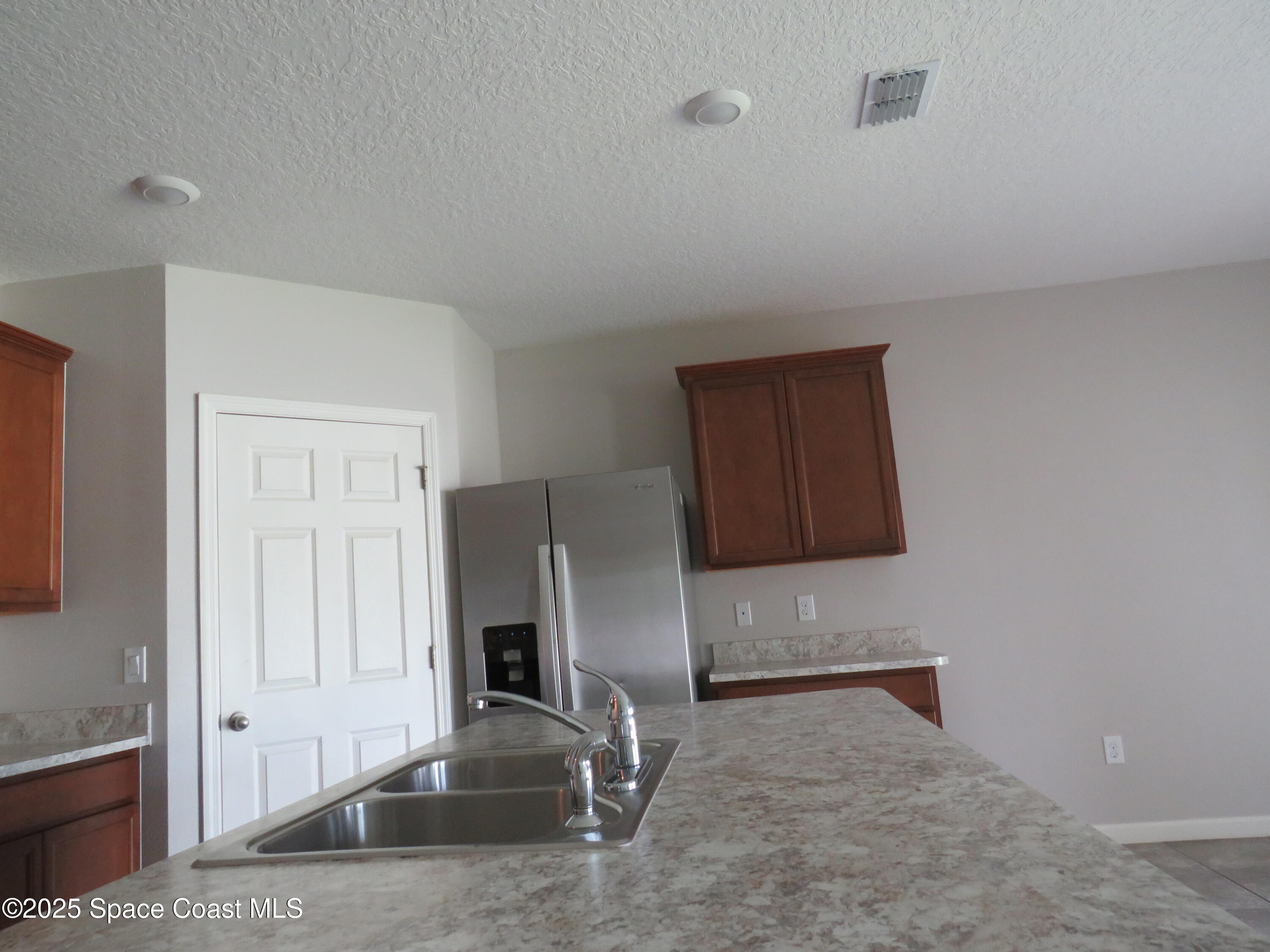 3548 Loggerhead Lane Mims, FL 32754 - Photo 6 of 25 a kitchen with granite countertop a refrigerator and a stove top oven