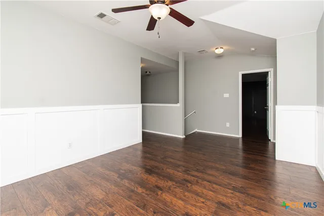 a view of an empty room with wooden floor