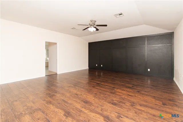 a view of an empty room with a ceiling fan