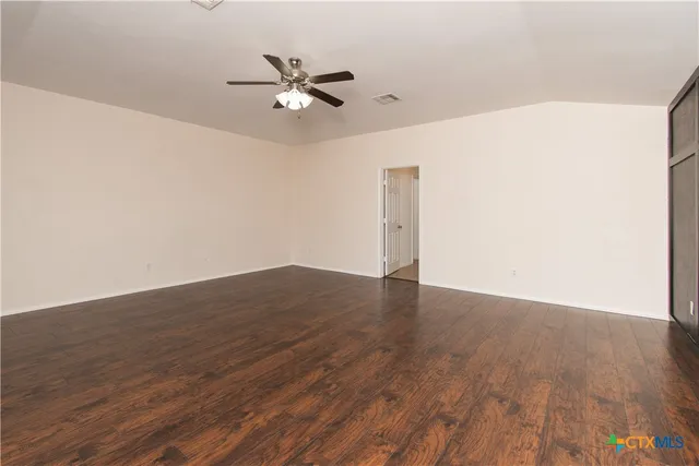 a view of a room with wooden floor and a ceiling fan