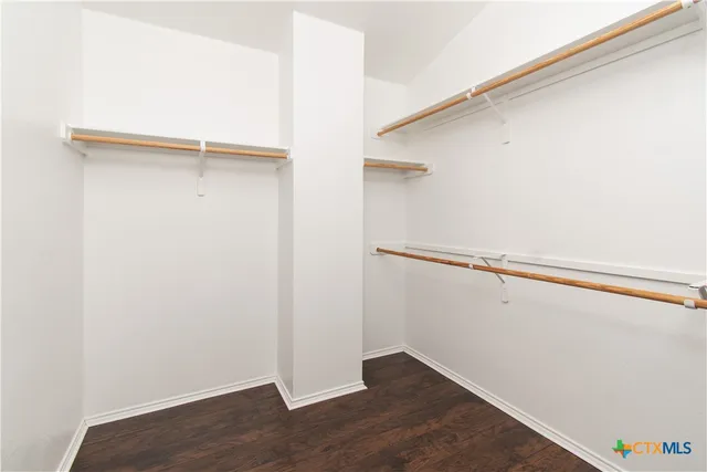 a view of walk in closet with empty racks