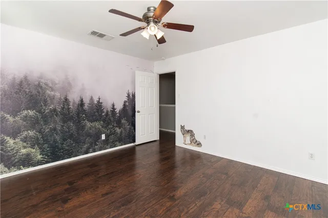 a view of a big room with wooden floor and a ceiling fan