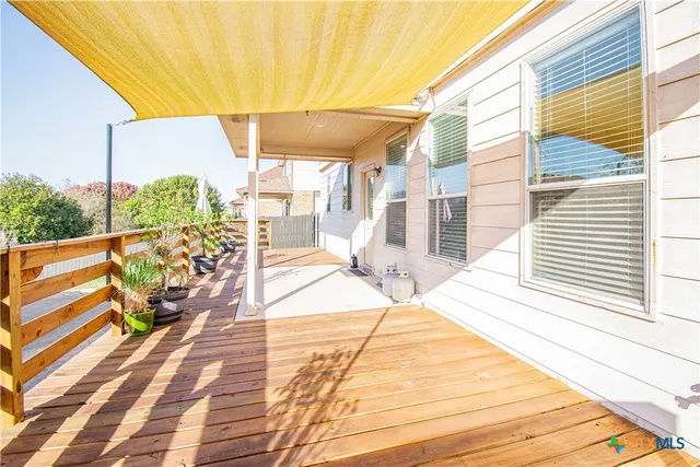 a view of a balcony with wooden floor and fence