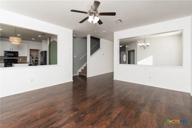 a view of a kitchen with wooden floor and a ceiling fan