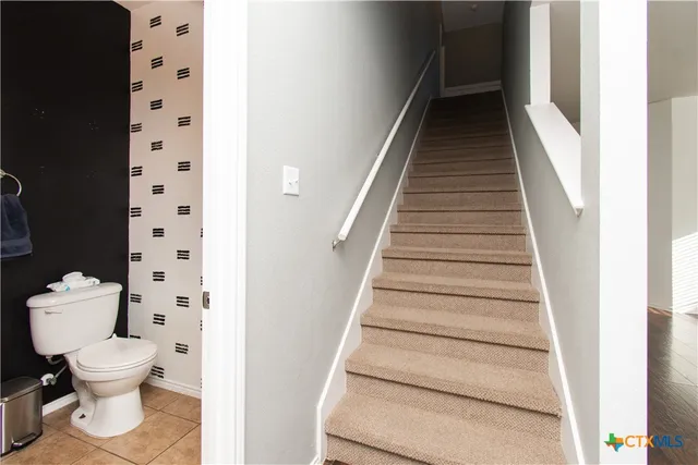 a bathroom with a toilet and a mirror