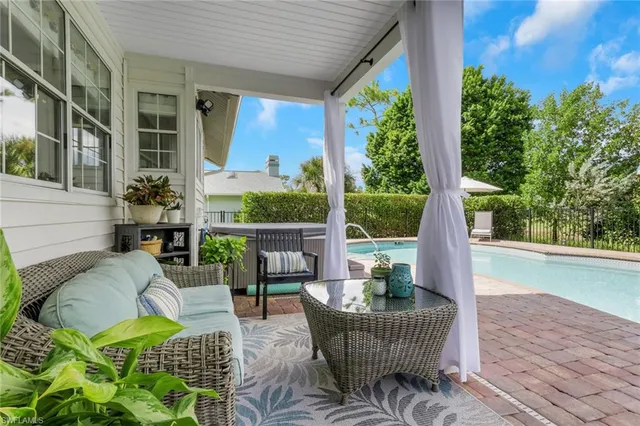 a view of a patio with couches potted plants and wooden floor