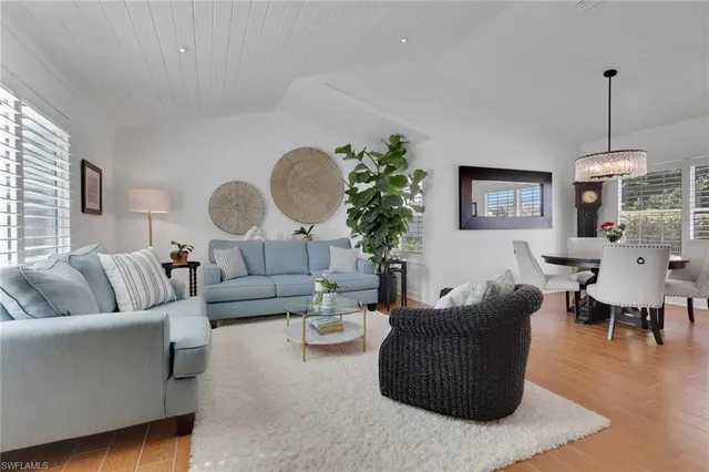 a living room with furniture potted plant and a chandelier