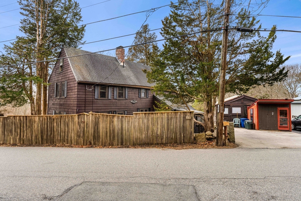 a front view of a house with a tree