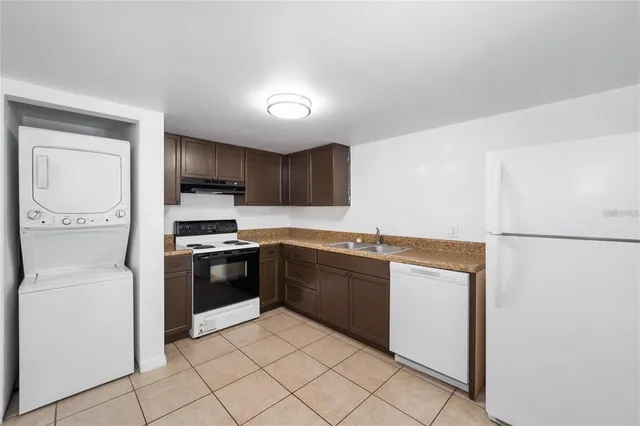 a kitchen with stainless steel appliances granite countertop a refrigerator sink and stove