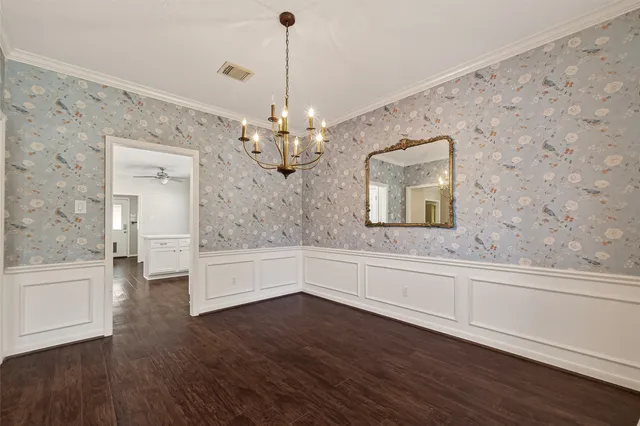 a room with a wooden floor and chandelier