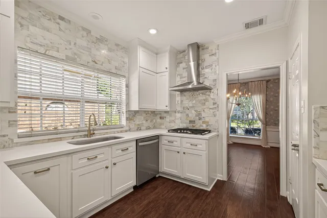 a kitchen with a white cabinets and wooden floor
