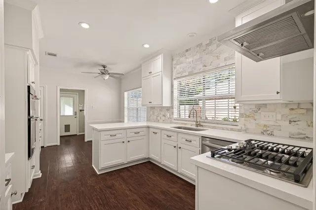 a kitchen with white cabinets and appliances