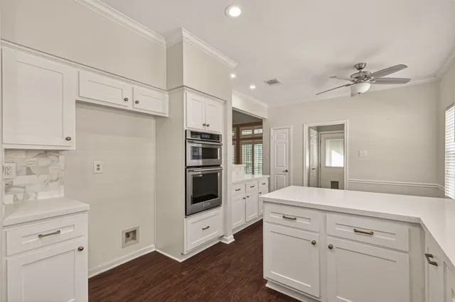 a kitchen with white cabinets and white appliances