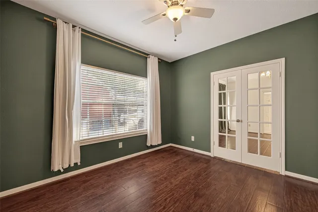 a view of an empty room with a window and wooden floor