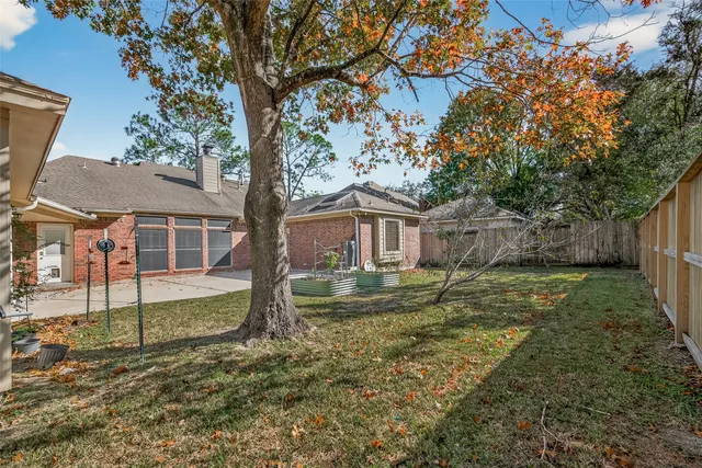 a view of a house with a yard and large tree