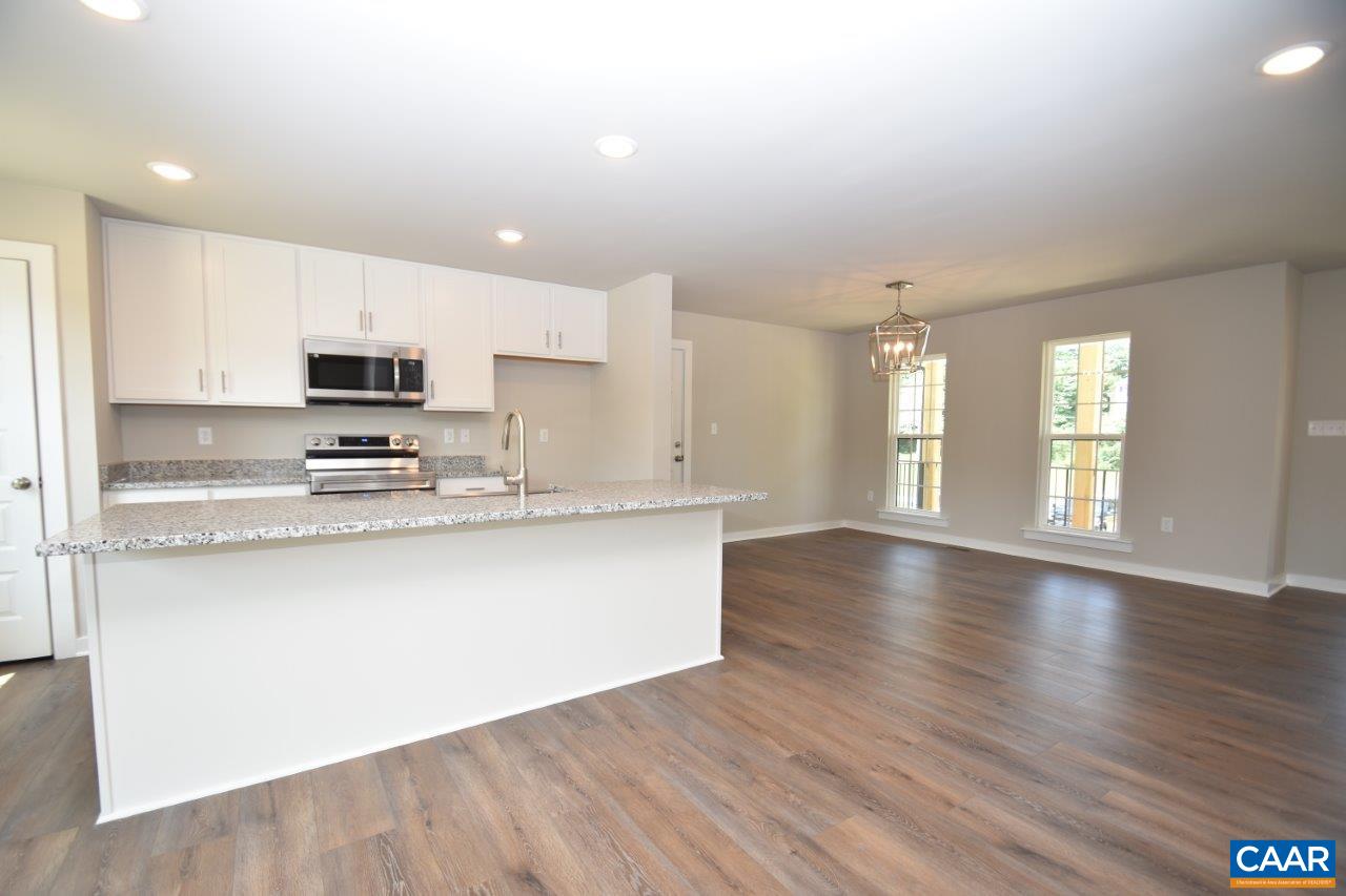 4696 Venable Road Kents Store, VA 23084 - Photo 6 of 28 a large kitchen with stainless steel appliances granite countertop a stove a sink a refrigerator and white cabinets with wooden floor