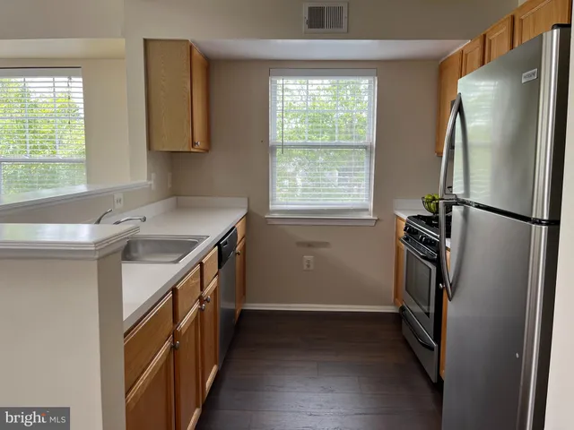a kitchen with a sink a refrigerator a stove and a window