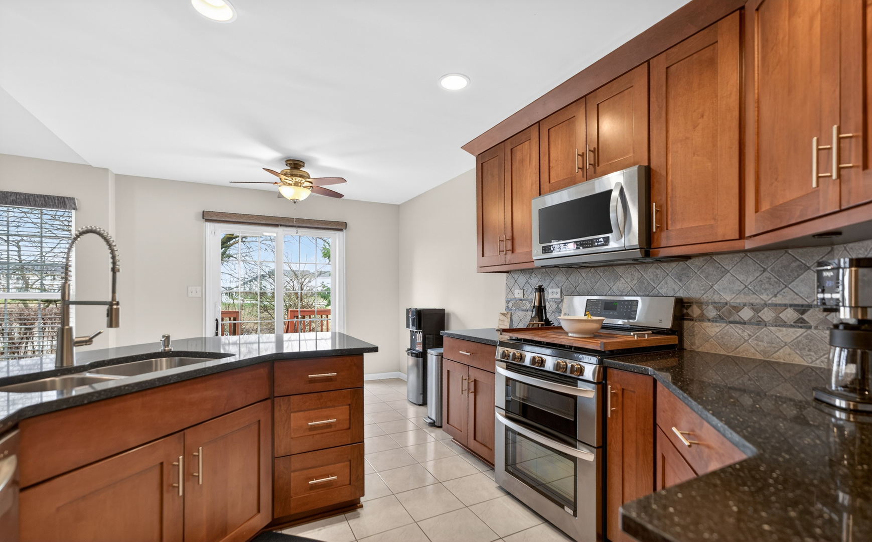 125 Ione Drive, Unit A South Elgin, IL 60177 - Photo 17 of 44 a kitchen with stainless steel appliances granite countertop wooden cabinets stove top oven and sink