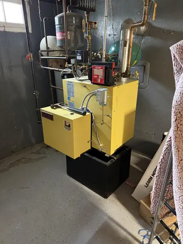 a room with water heater and wooden cabinets