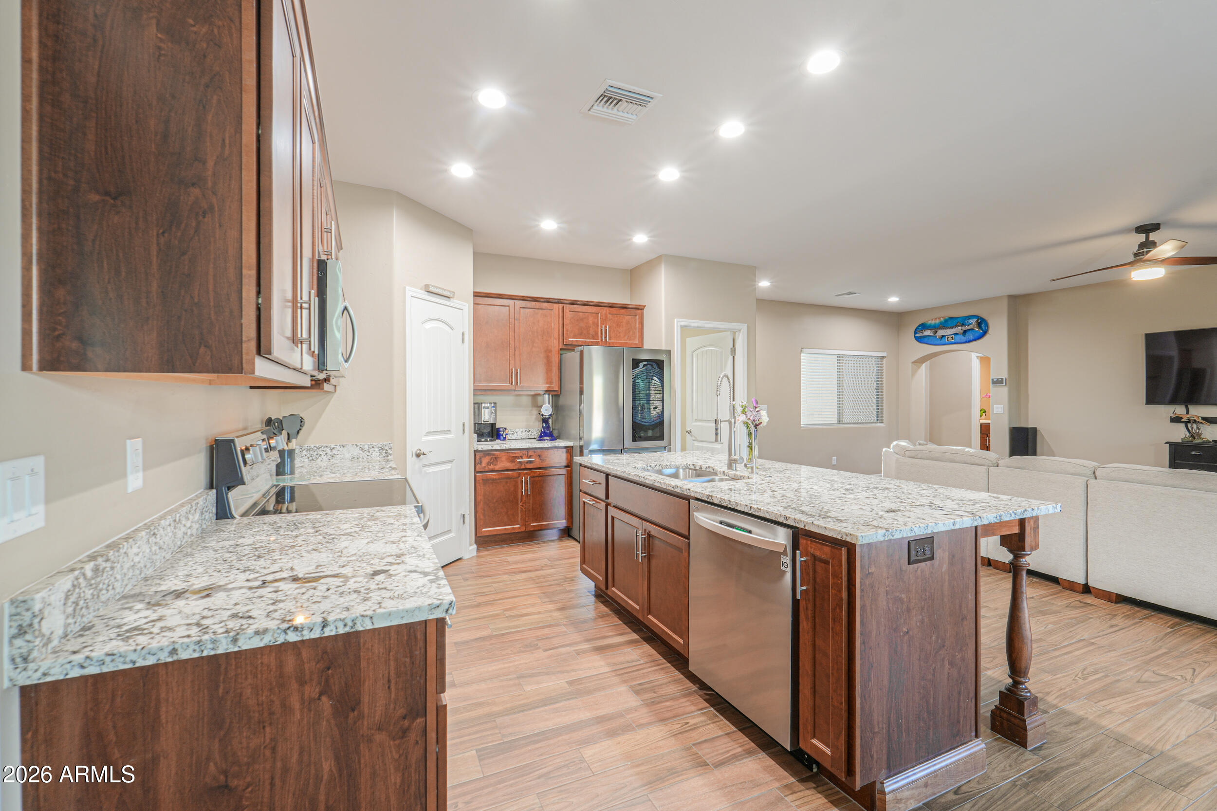 1487 South Mountain View Road Apache Junction, AZ 85119 - Photo 14 of 60 a kitchen with granite countertop kitchen island a sink stove and wooden cabinets