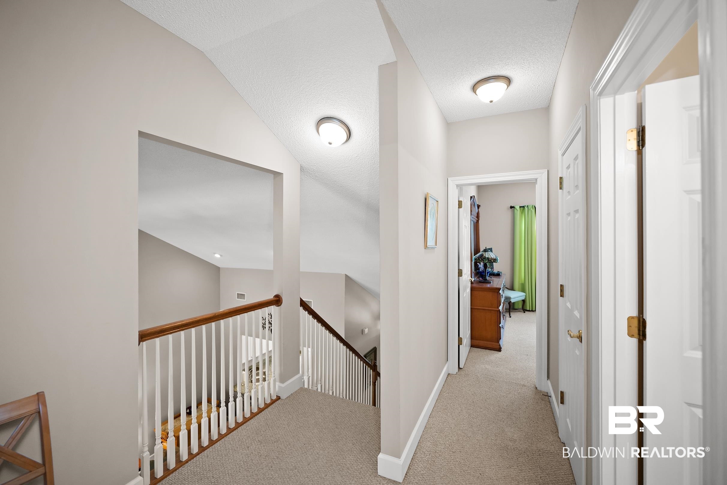 430 West Fort Morgan Road, Unit 704 Gulf Shores, AL 36542 - Photo 19 of 35 Upper-level hallway featuring neutral wall paint, carpeted flooring, and white trim