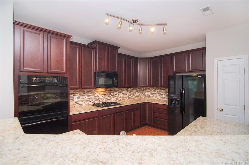 7510 Turley Ridge Lane Charlotte, NC 28273 - Photo 2 of 23 a kitchen with granite countertop wooden cabinets and refrigerator