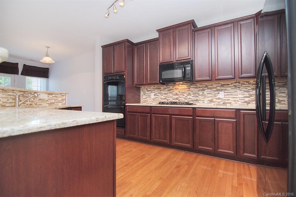 7510 Turley Ridge Lane Charlotte, NC 28273 - Photo 4 of 23 a kitchen with granite countertop wooden cabinets and stainless steel appliances