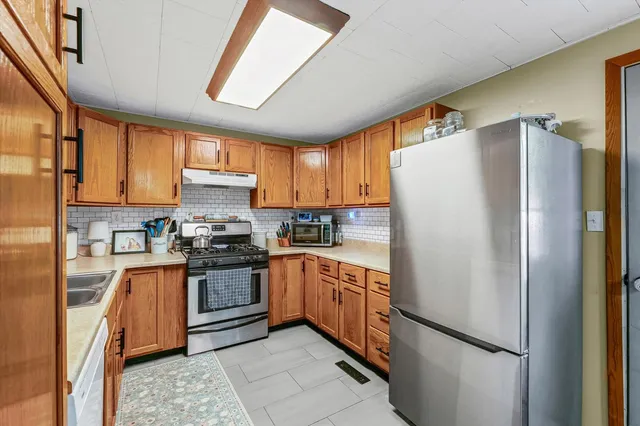 a kitchen with stainless steel appliances granite countertop a refrigerator and a stove top oven