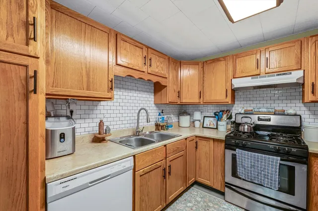 a kitchen with stainless steel appliances granite countertop a sink stove and cabinets
