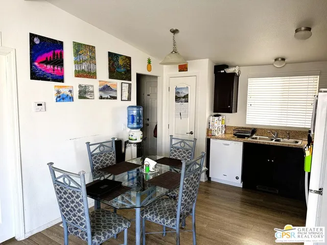 a kitchen with stainless steel appliances a refrigerator a sink a stove a table and chairs