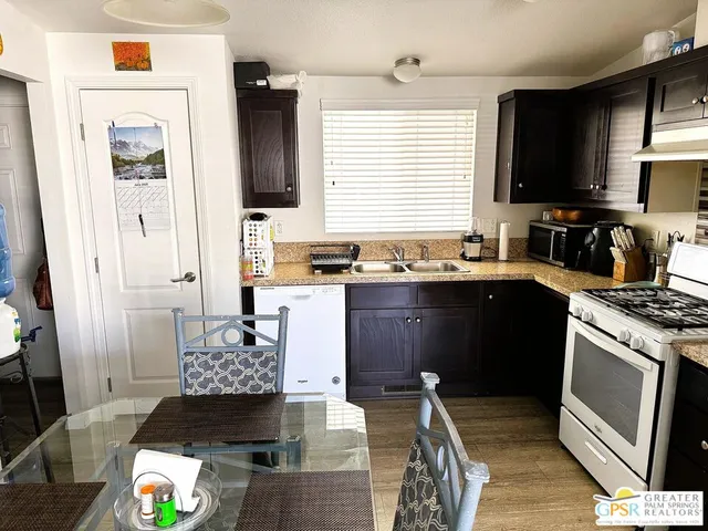 a kitchen with a refrigerator and wooden floor