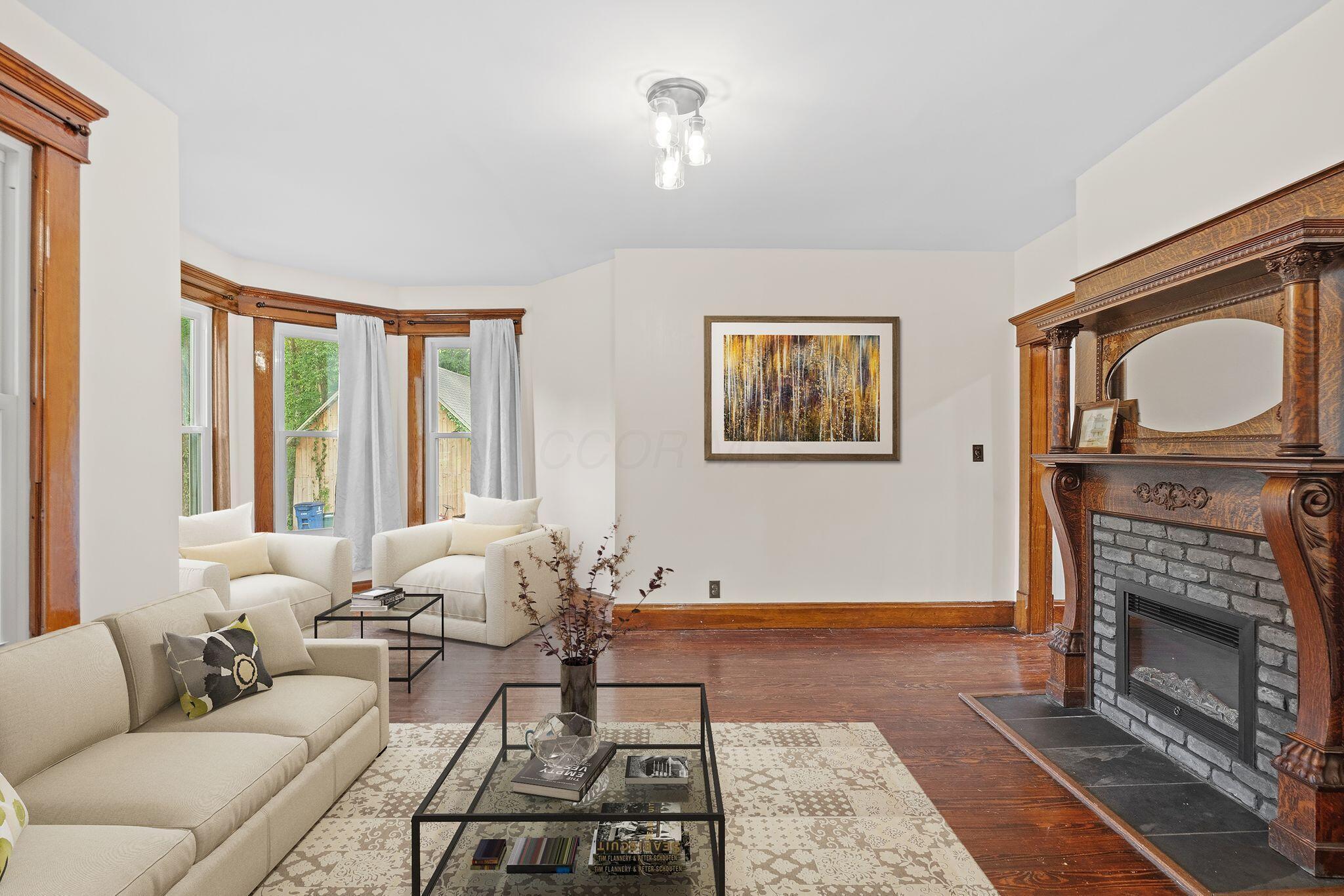 107 Price Road Columbus, OH 43230 - Photo 4 of 51 Virtual Staging. Ornate wood mantel fireplace with a black stone hearth and gray brick surround