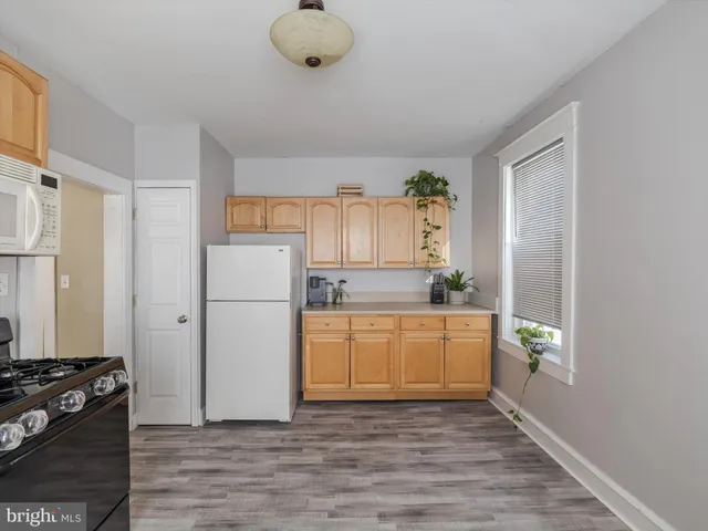 a kitchen with a refrigerator and a stove top oven
