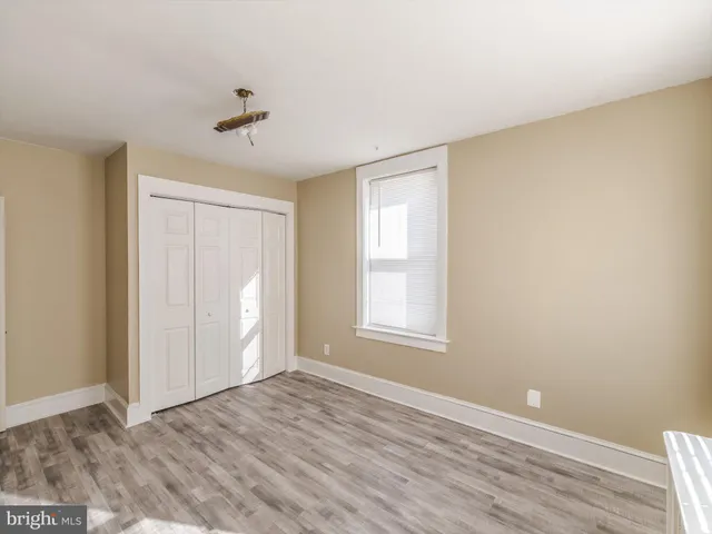 an empty room with windows and closet