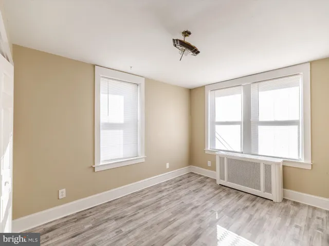 an empty room with a window and wooden floor