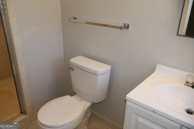 a white toilet sitting next to a white sink and vanity