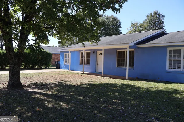 a view of a yard in front of a house with large tree