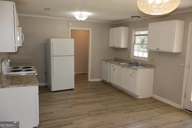 a kitchen with a refrigerator a stove and a wooden floor