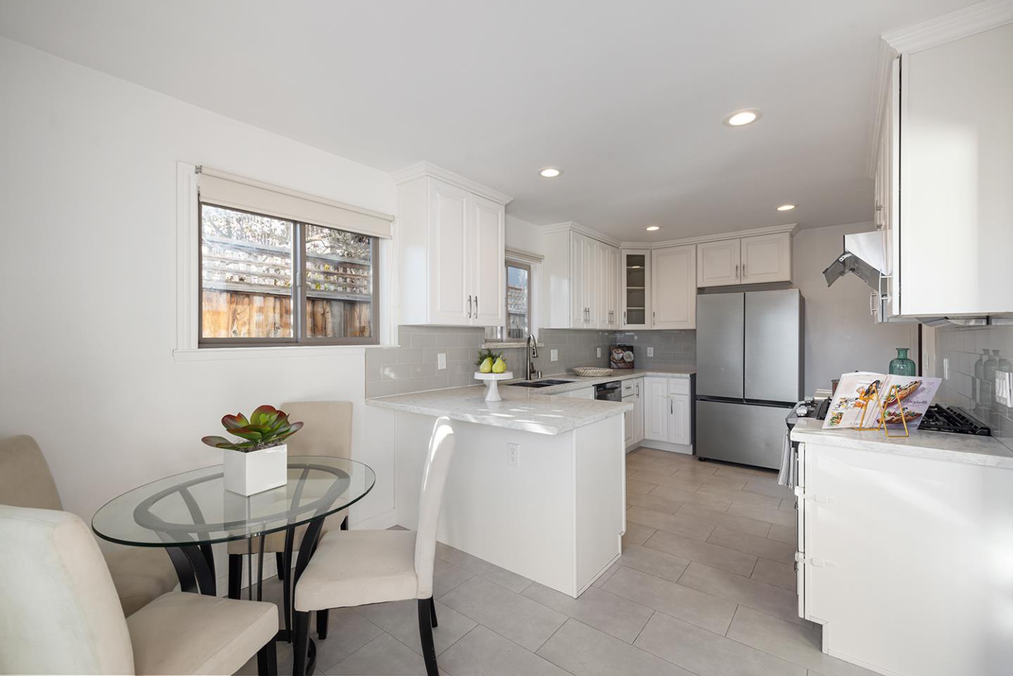943 Hillcrest Boulevard Millbrae, CA 94030 - Photo 22 of 51 a kitchen with a sink a refrigerator and white cabinets