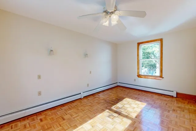 a view of empty room with window and ceiling fan