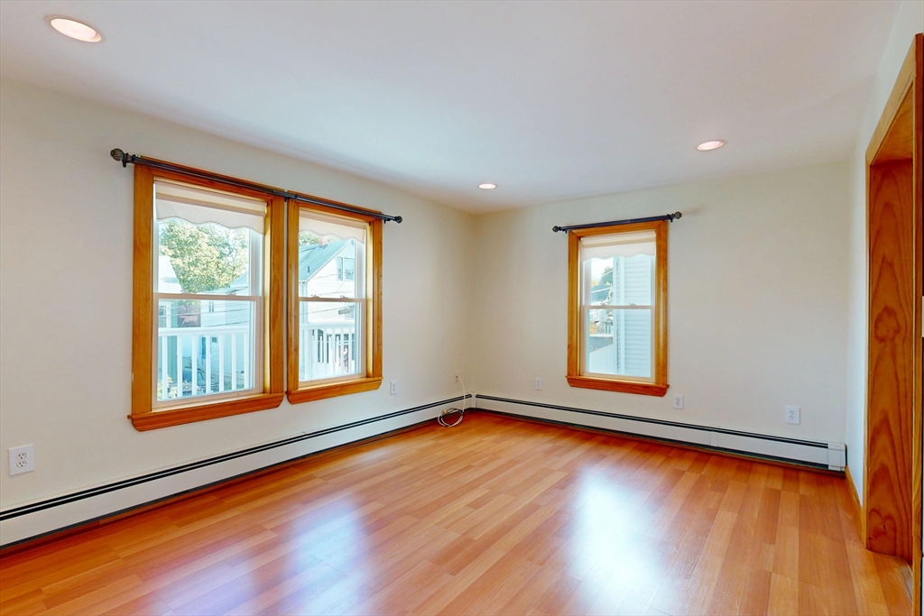 58 Teel Street, Unit 58 Arlington, MA 02474 - Photo 8 of 22 a view of an empty room with wooden floor and a window