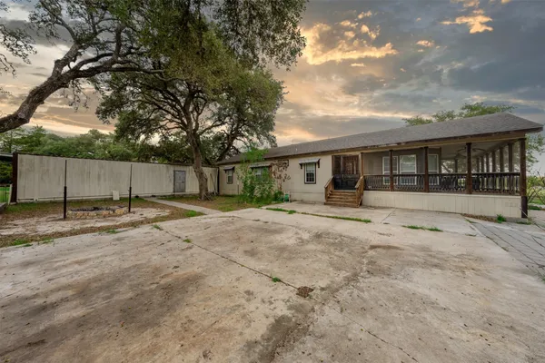 a view of a house with backyard and a tree