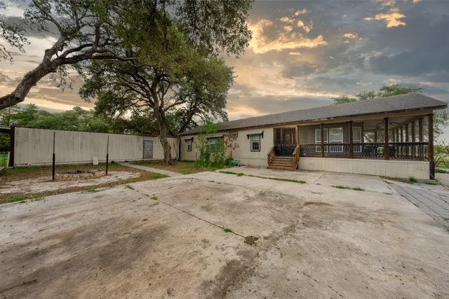 a view of a house with backyard and a tree