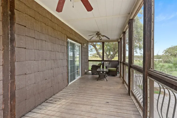 a view of a porch with wooden floor and furniture