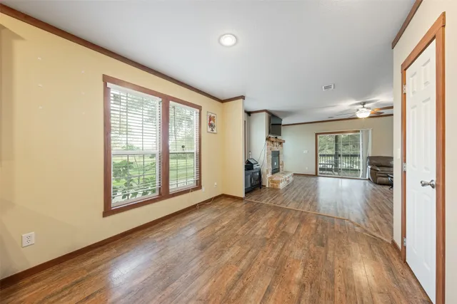 a view of a kitchen with kitchen island wooden floors stainless steel appliances